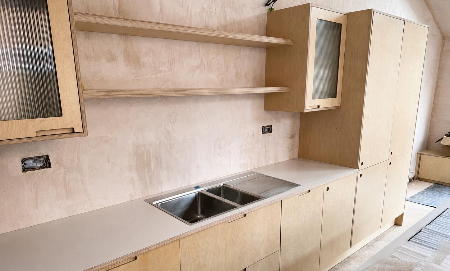 Finished light oak kitchen with fluted-glass wall cabinets, open shelves, sink run and tall pantry units